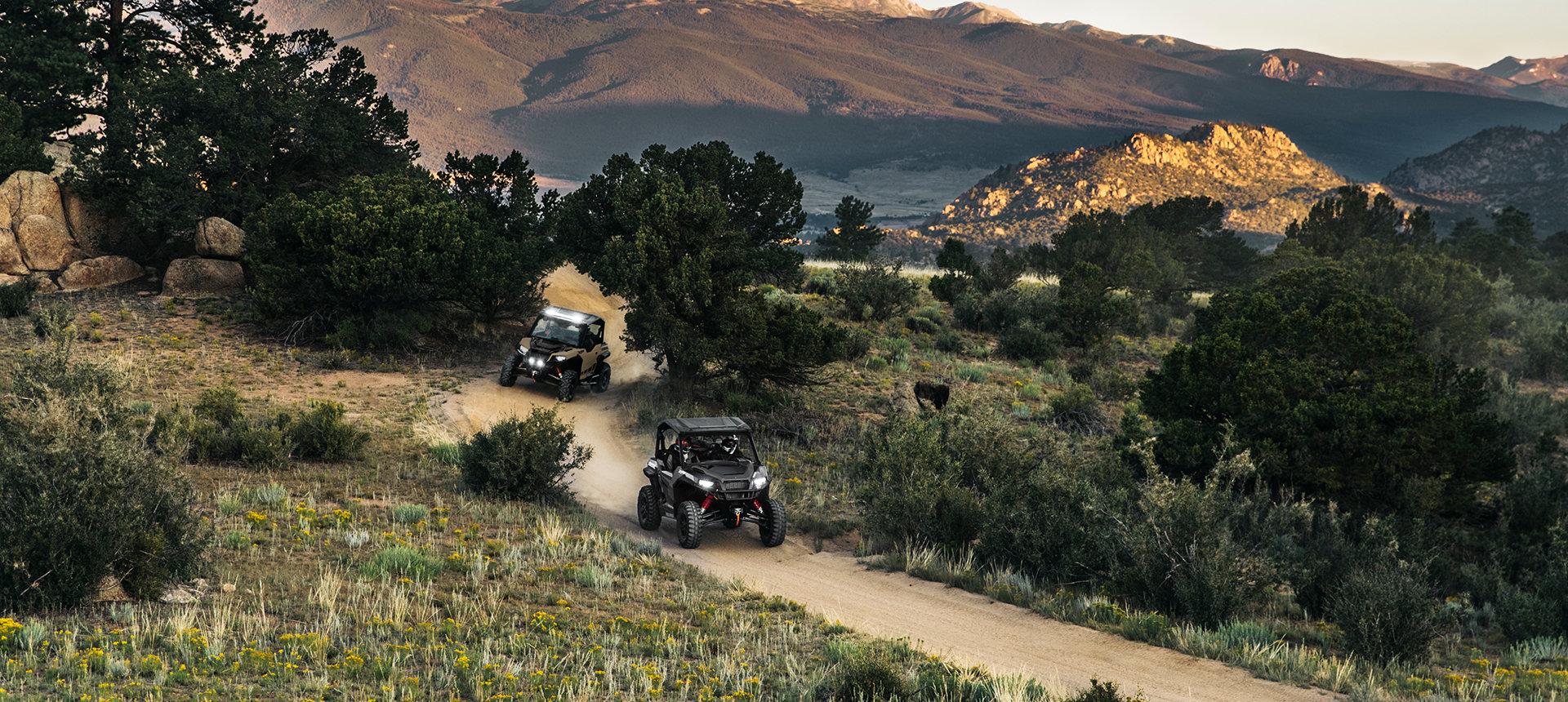Two General XP 1000 vehicles riding on a trail in the woods
