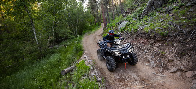 Sportsman 570 on a trail road