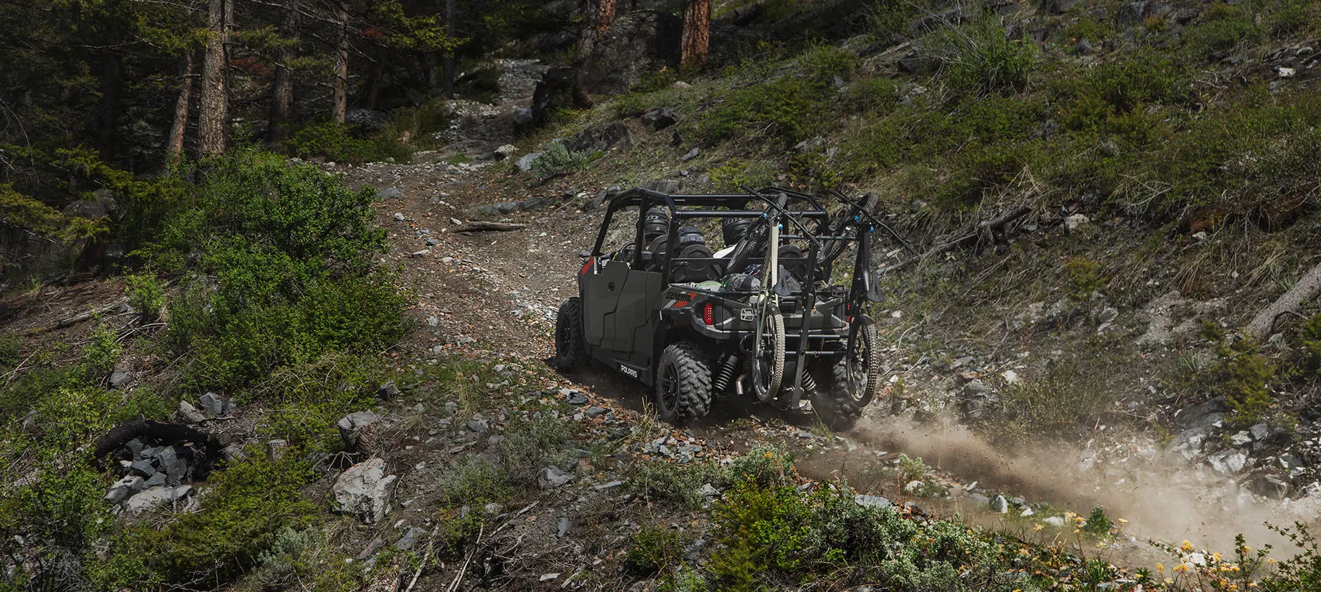 Polaris General 4 1000 side by side hauling 2 bikes up a rocky hill