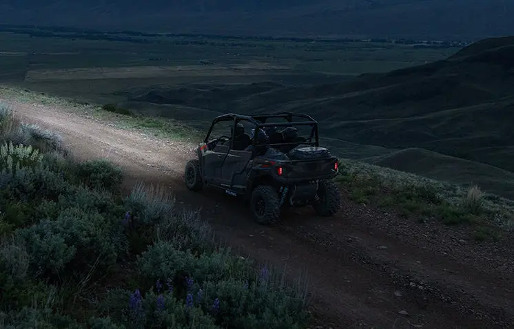 Polaris General 4 1000 side by side driving on a trail at night