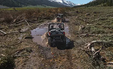 Polaris General 1000 side by side driving through a mud hole with ease