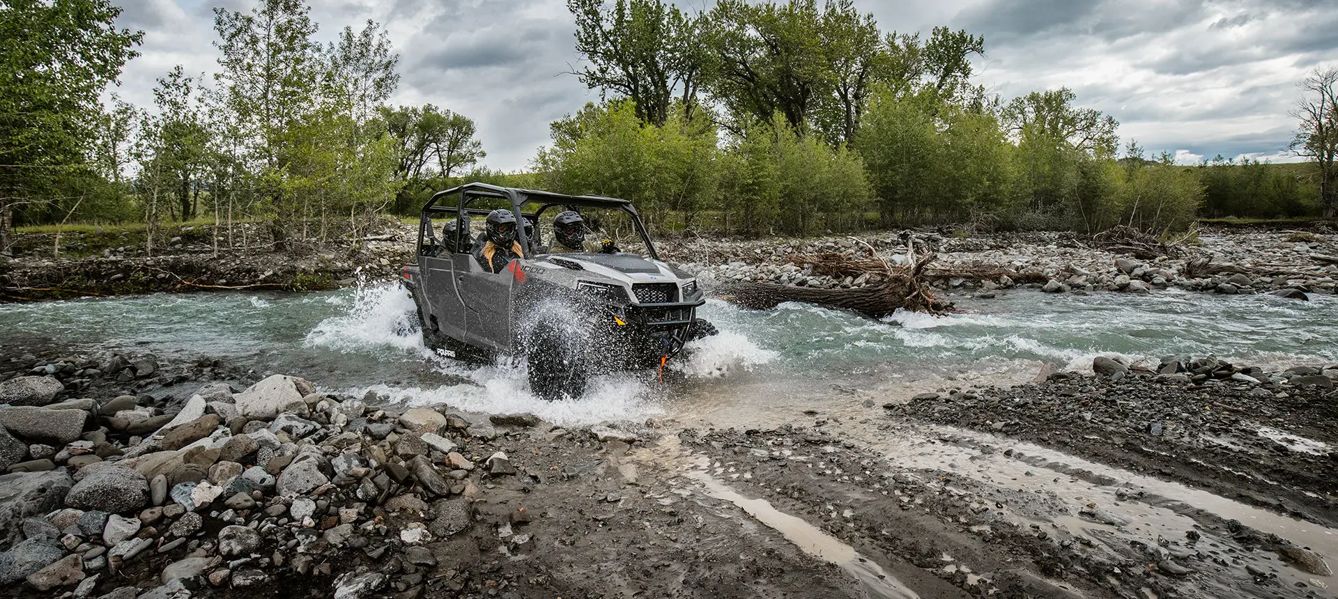 Polaris General 1000 side by side driving through a mud hole with ease