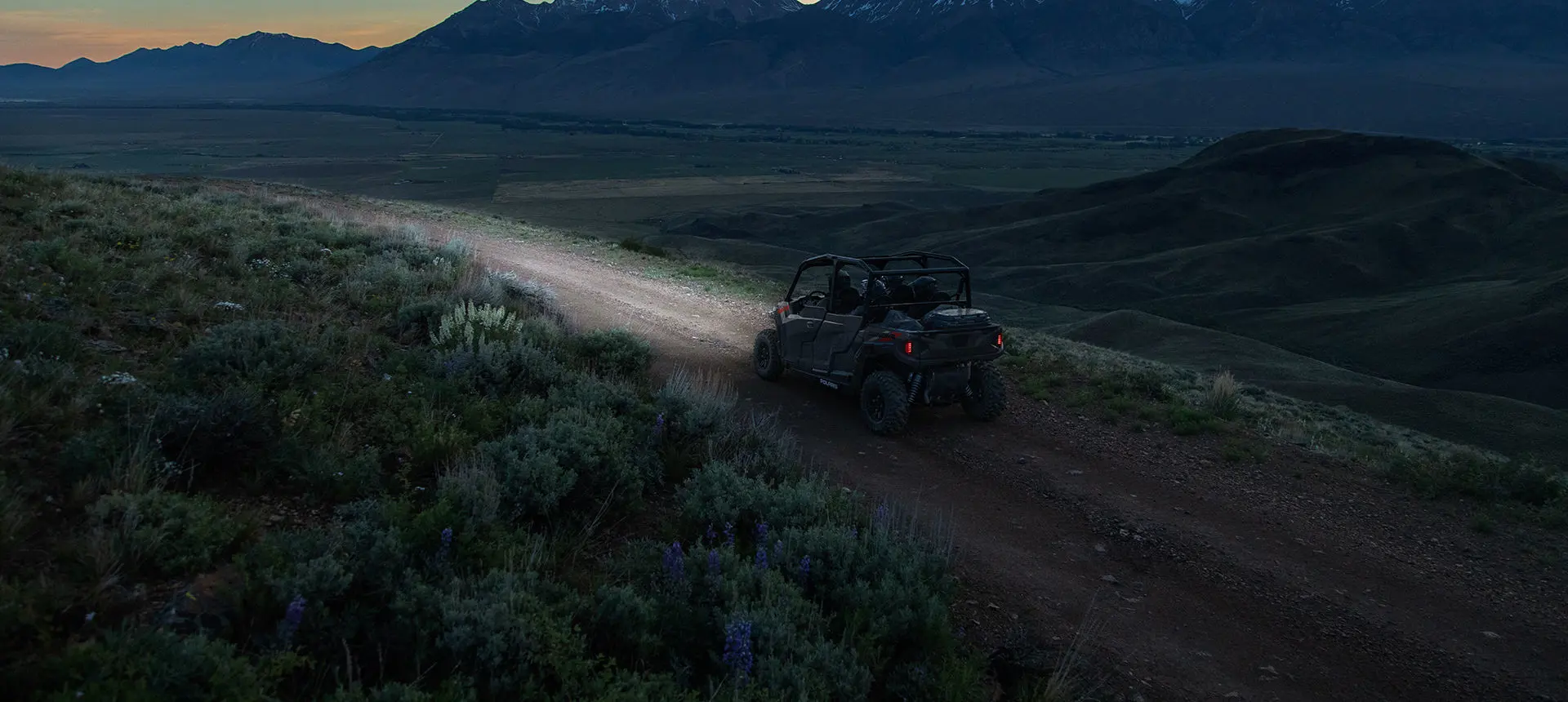 Polaris General 4 1000 side by side driving down a trail at night
