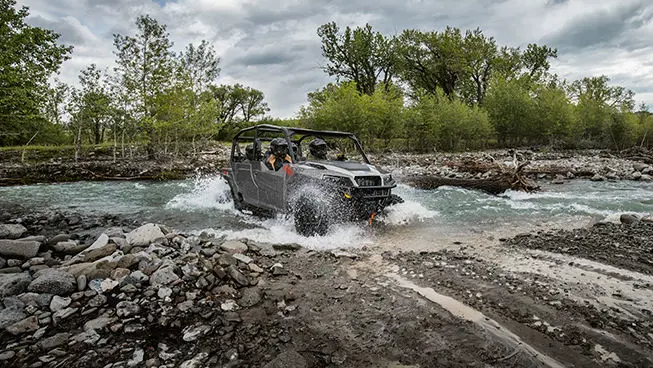 Polaris General 1000 side by side driving through a mud hole with ease