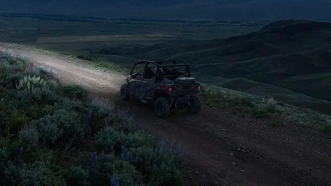 Polaris General 4 1000 side by side driving down a trail at night