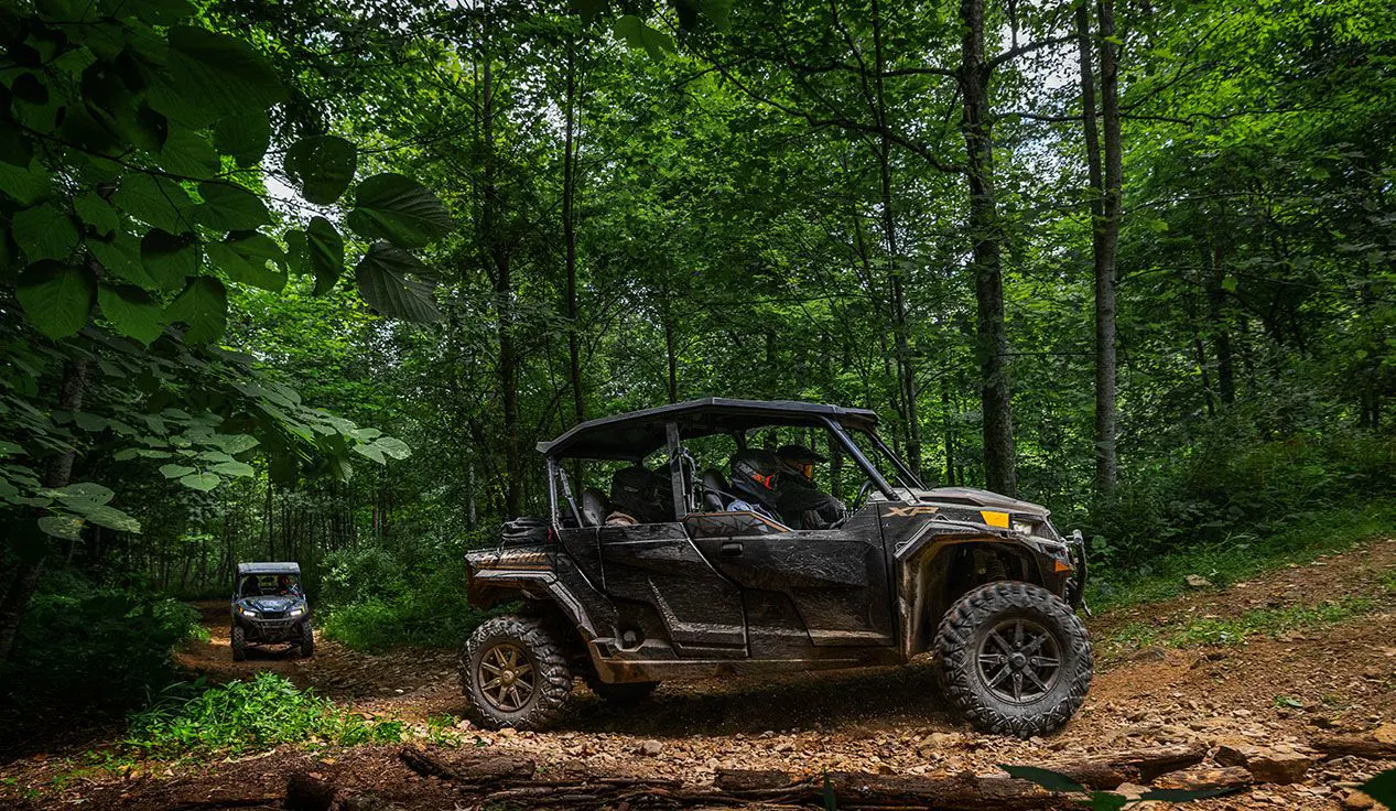 Fully loaded Polaris General XP 4 1000 side by side cruising on a forest trail