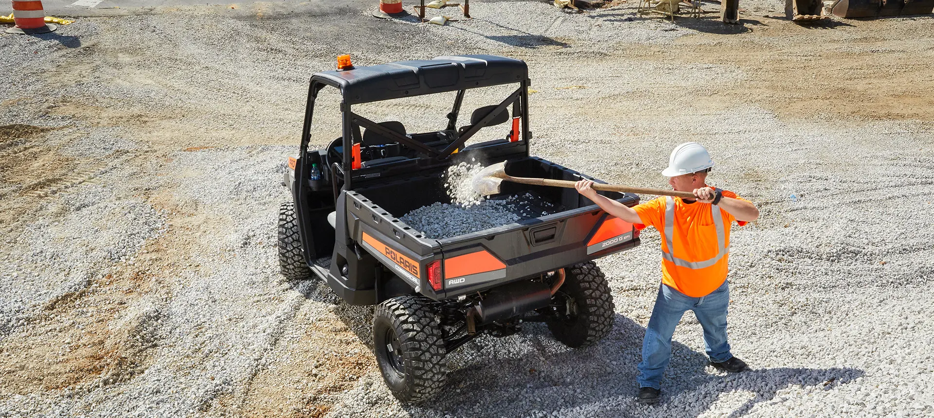 construction worker loading gravel into the cargo box of a pro xd full-size diesel work UTV