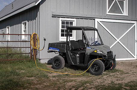 a ranger ev charging near a barn on a farm