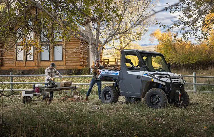 loading split wood into the cargo bed of a ranger xp kinetic side by side
