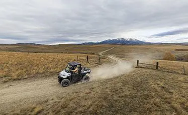 ranger xp kinetic side by side kicking up dust on a trail