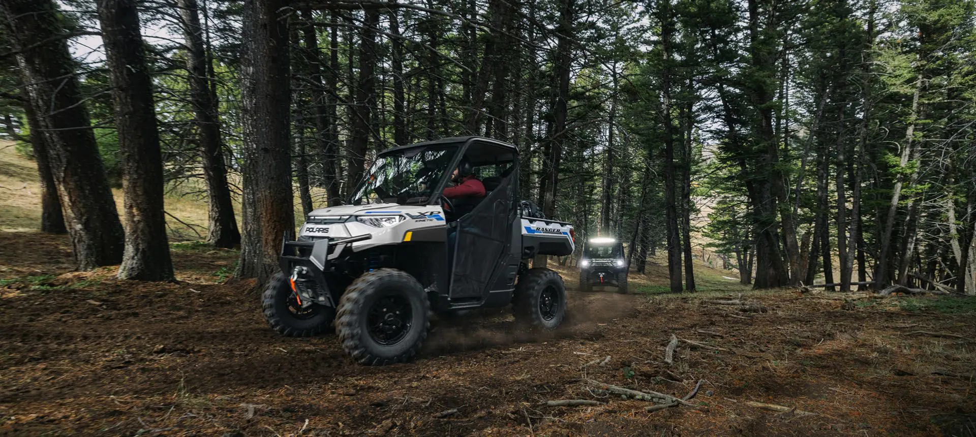 side view of a ranger xp kinetic utv leading on a trail