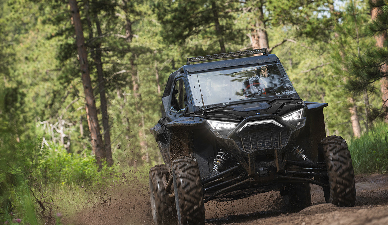 Front view of a RZR Pro XP riding on a muddy trail