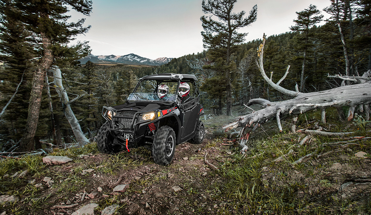 RZR trail 570 making a turn on a trail in the woods