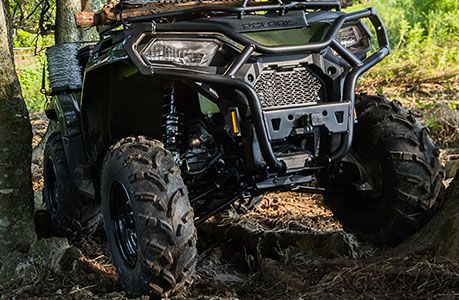 Sportsman 570 equipped with steel front brushguard parked in a muddy terrain