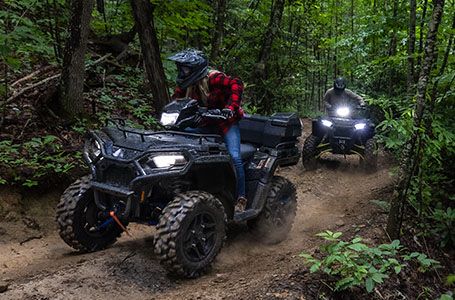 Two Sportsman 570 riding through the forest