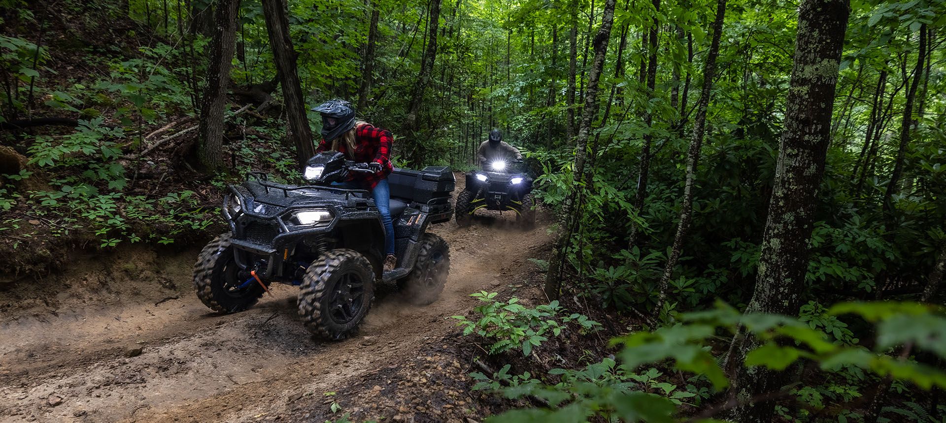 Two Sportsman 570 riding through the forest