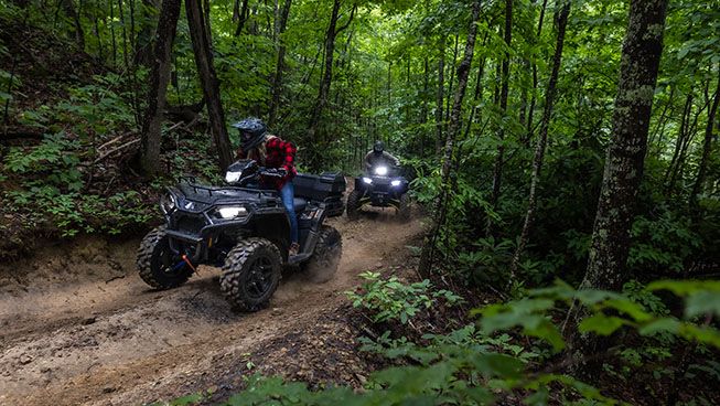 Two Sportsman 570 riding through the forest