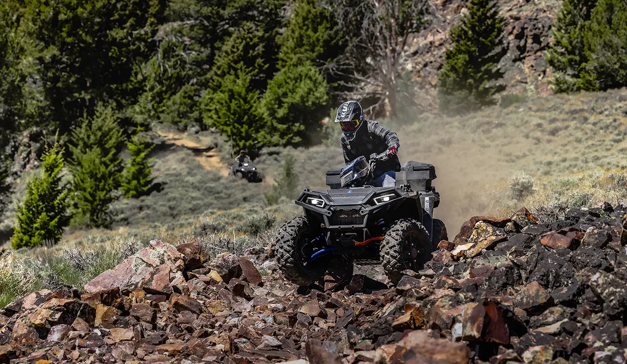 sportsman 850 with front and rear brushguard cruising down a rocky trail