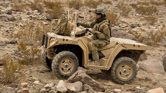 soldier driving a fully loaded sportsman mv850 tactical atv
