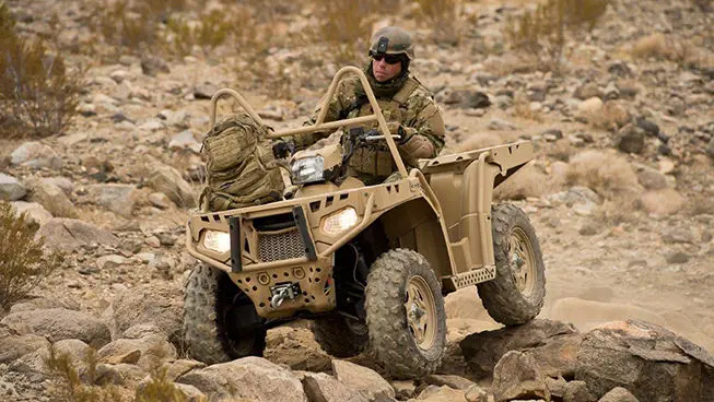 soldier driving a sportsman mv850 tactical atv over rocky terrain