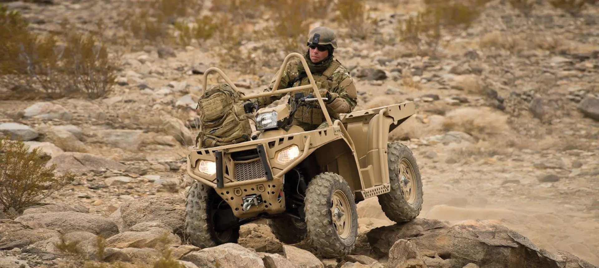 soldier driving a sportsman mv850 tactical atv over rocky terrain