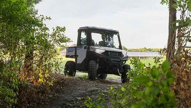 4 riders in a ranger crew sp 570 utv driving in a field