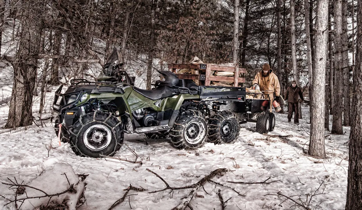 people using a sportsman 6x6 570 atv to move wood