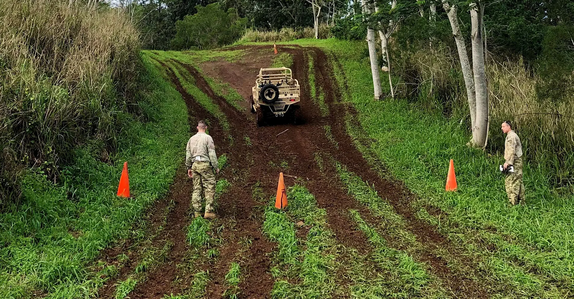 Two militaries training with a Military vehicle