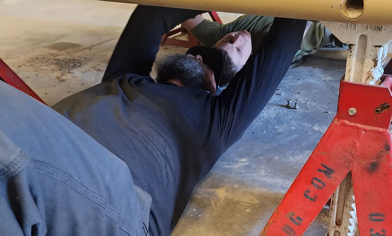 Two mechanics inspecting a military vehicle