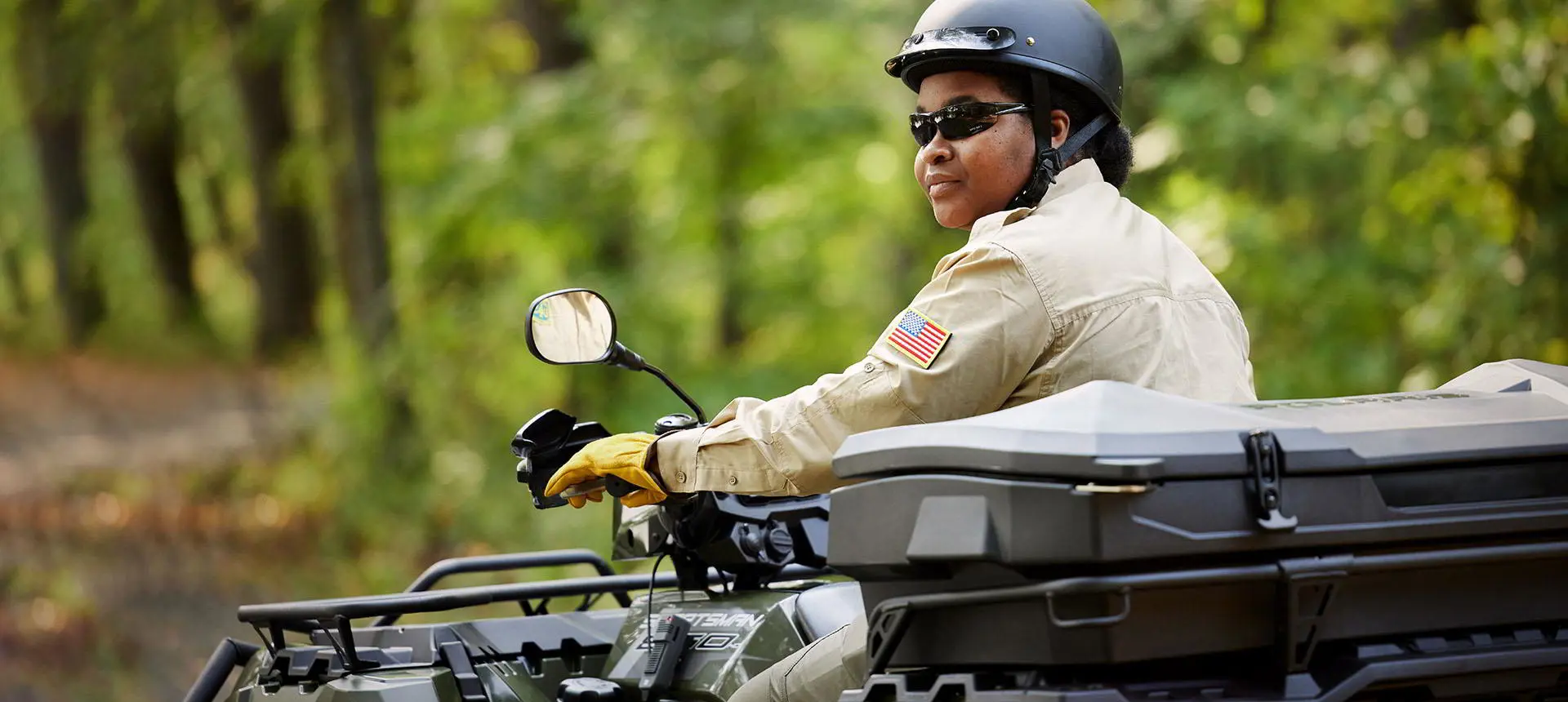 government official riding a polaris sportsman atv with a terrain and wildlife management package
