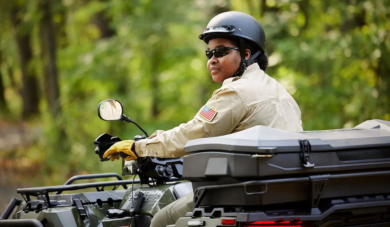 government official riding a polaris sportsman atv with a terrain and wildlife management package