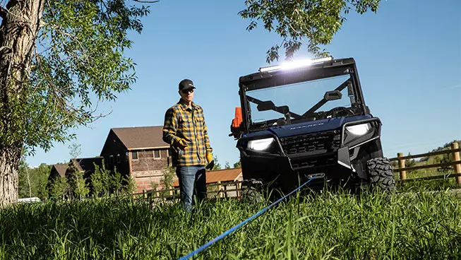man using the winch on his ranger 1000 utv