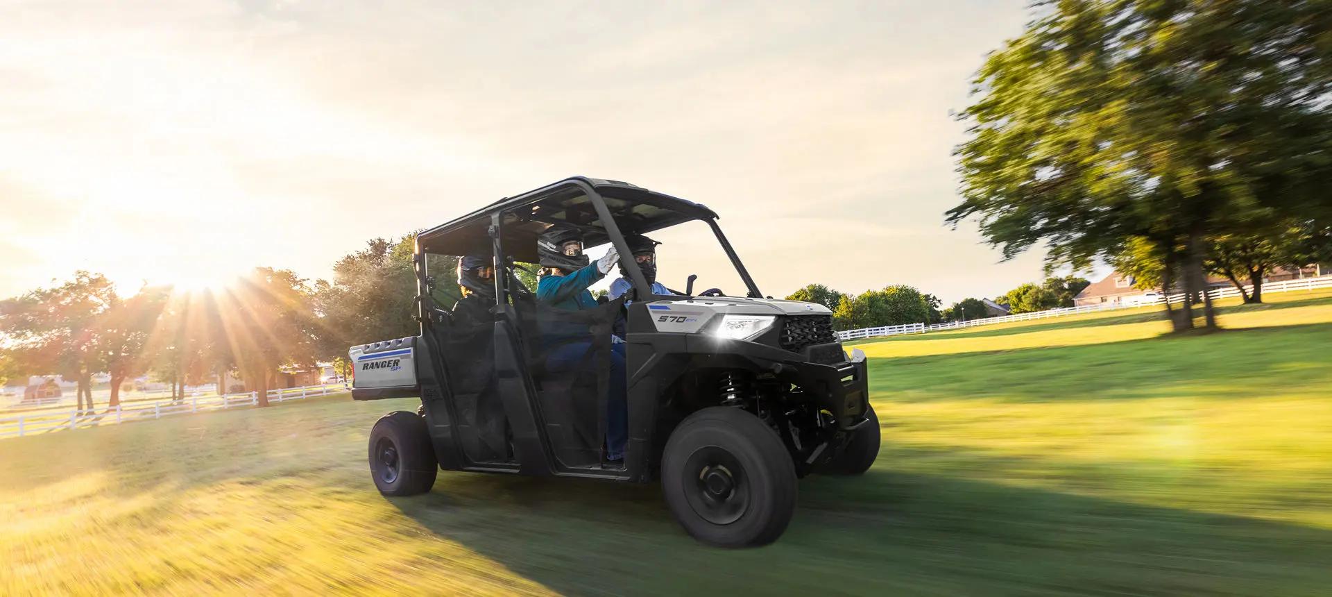 4 riders in a ranger crew sp 570 utv driving in a field