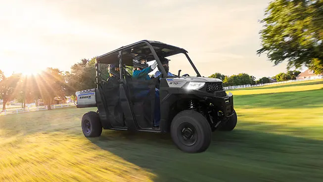 4 riders in a ranger crew sp 570 utv driving in a field