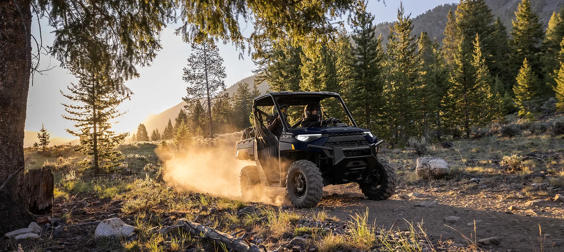2 riders in a ranger xp 1000 utv on a trail