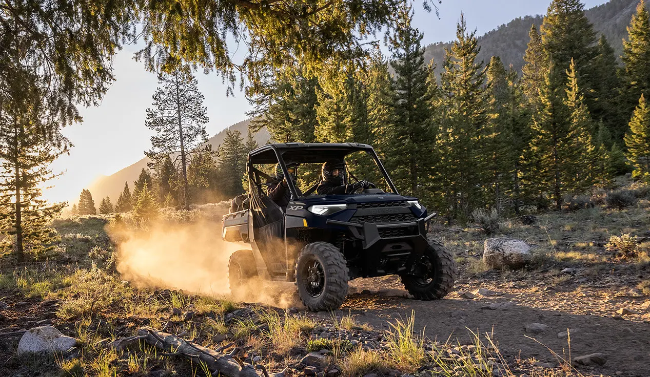 2 riders in a ranger xp 1000 utv on a trail