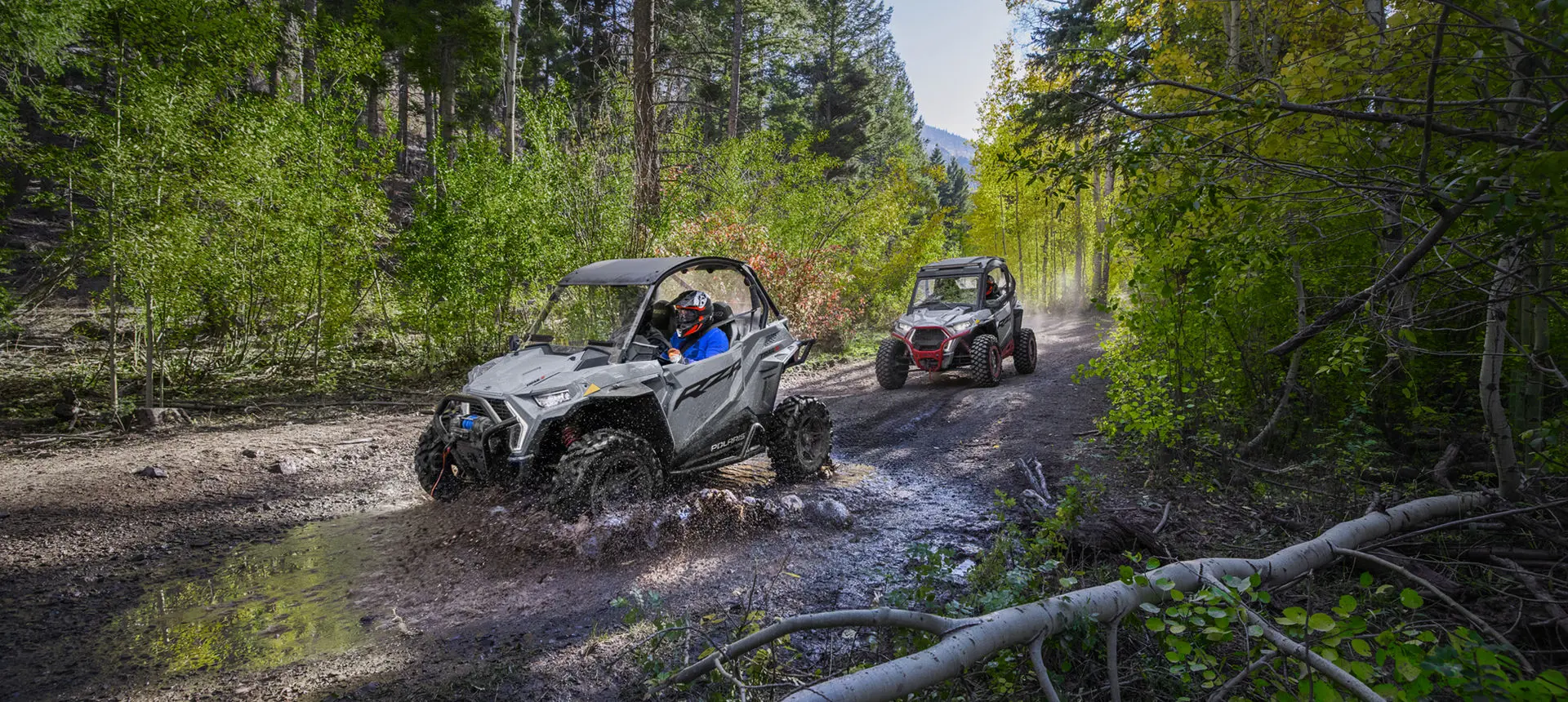 rzr trail s side by side driving into a mud puddle