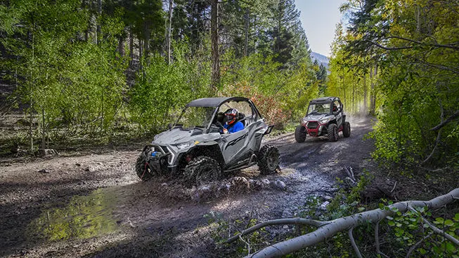 rzr trail s side by side driving into a mud puddle