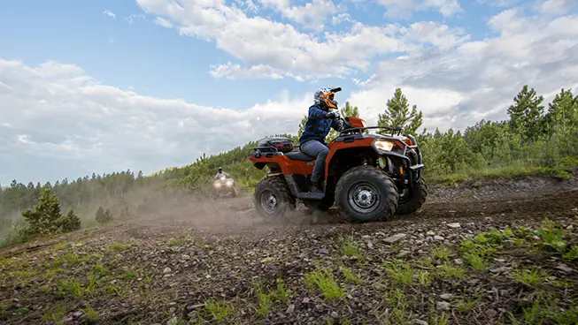 sportsman 570 atv cruising around a corner with another atv following