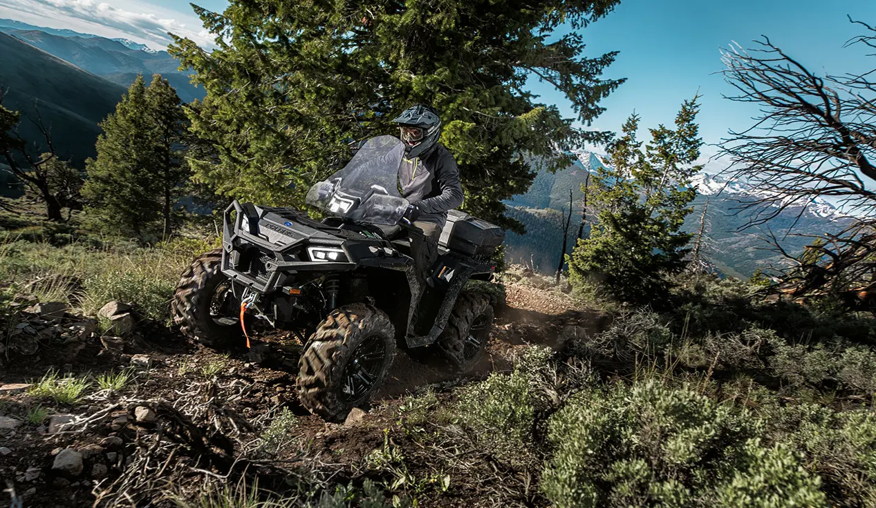 sportsman xp 1000 atv cruising on a mountain trail