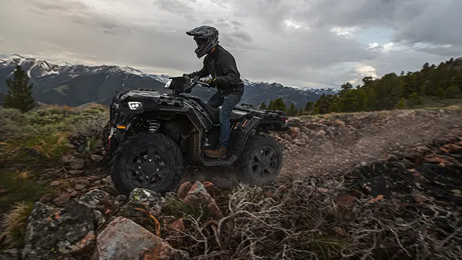 side profile of a sportsman xp 1000 atv on a rocky mountain trail