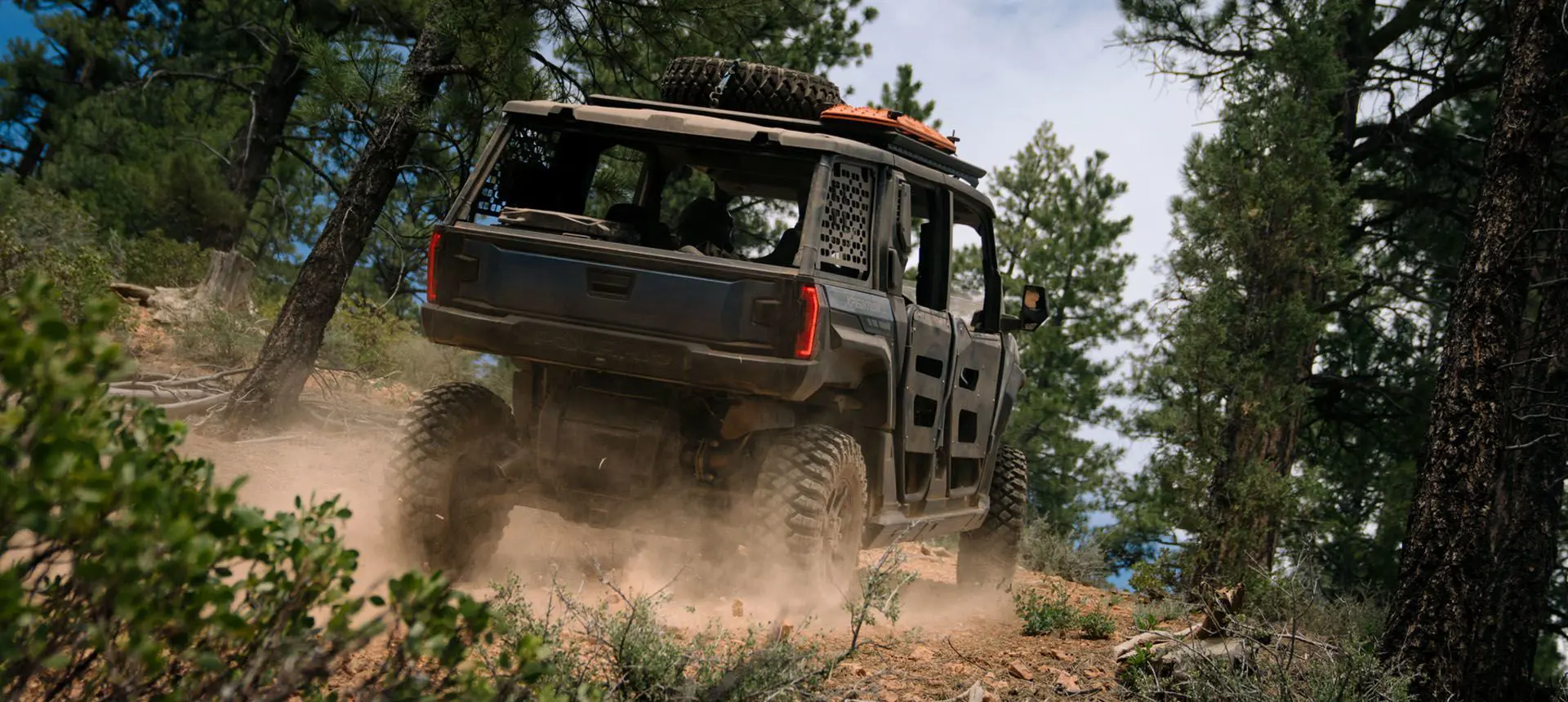 rear view of a polaris xpedition adv 5 side by side on a forest trail