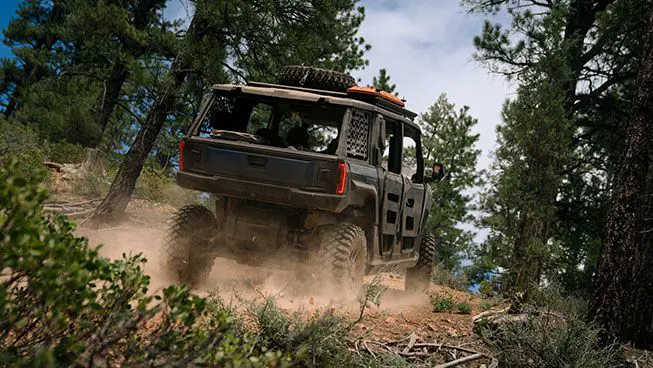 rear view of a polaris xpedition adv 5 side by side on a forest trail