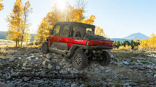 rear view of a RANGER CREW XD 1500 NorthStar Edition extreme duty utv crawling over rocky terrain