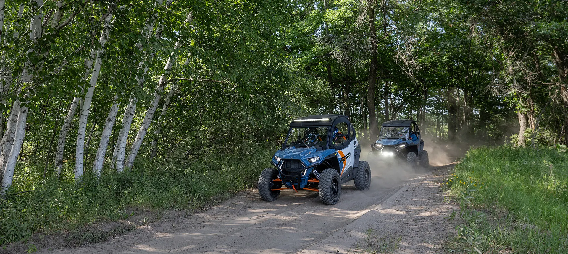 2 rzr trail side by sides on a dirt road