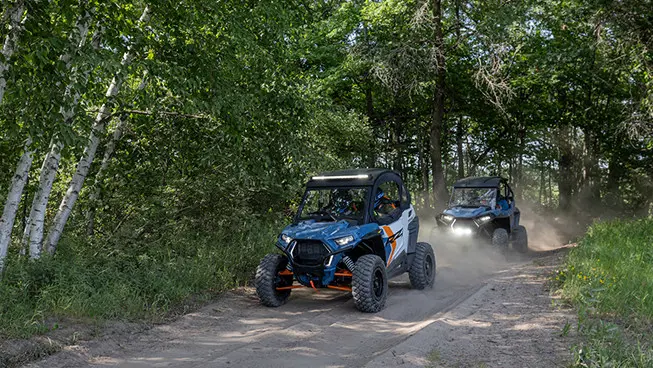 2 rzr trail side by sides on a dirt road
