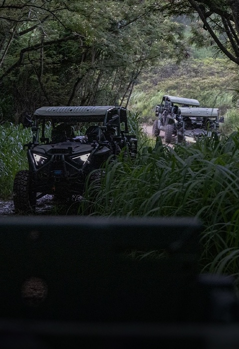 Three Polaris Military World-Class Ultra-Light Tactical vehicles are entering a jungle road.