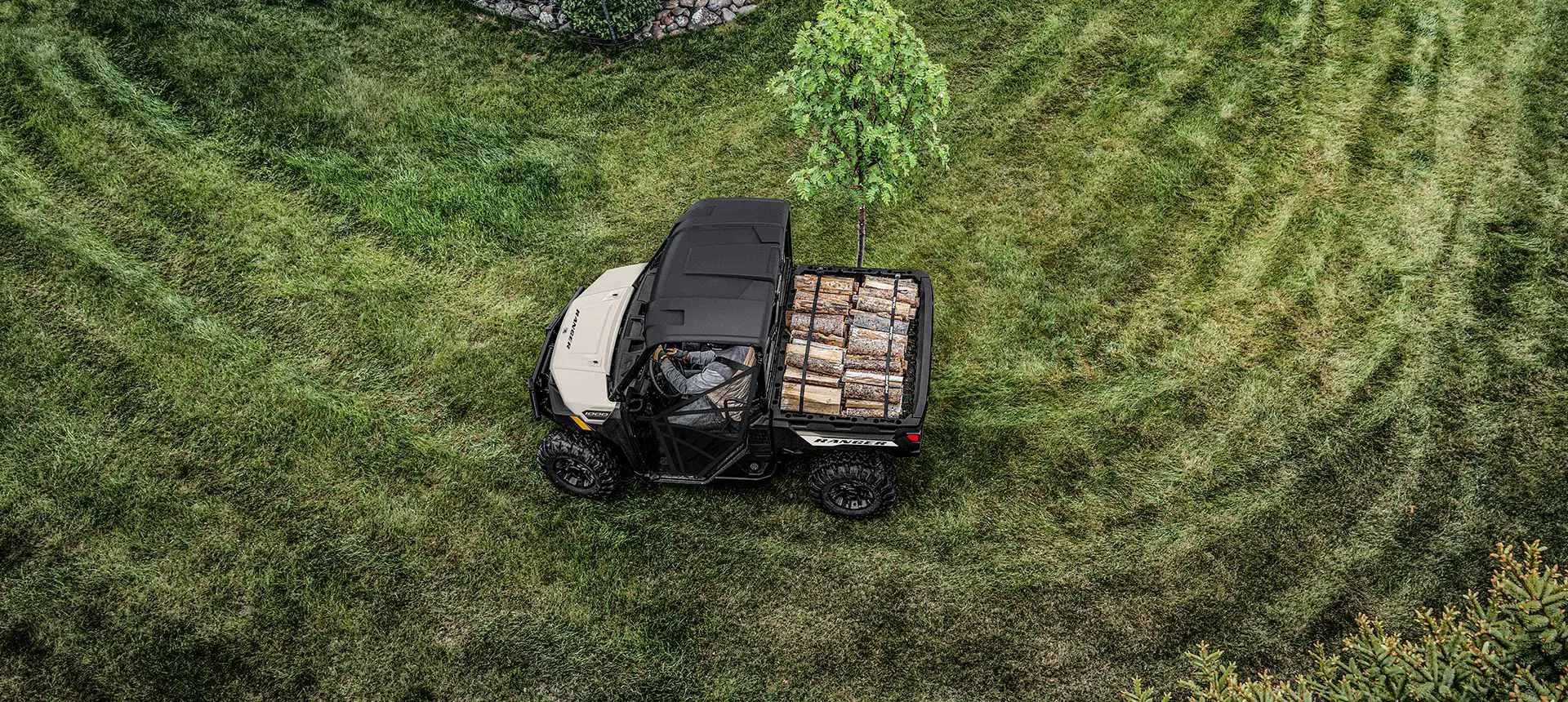 Aerial view of a Polaris RANGER 1000 UTV with a load of lumber in the cargo box.