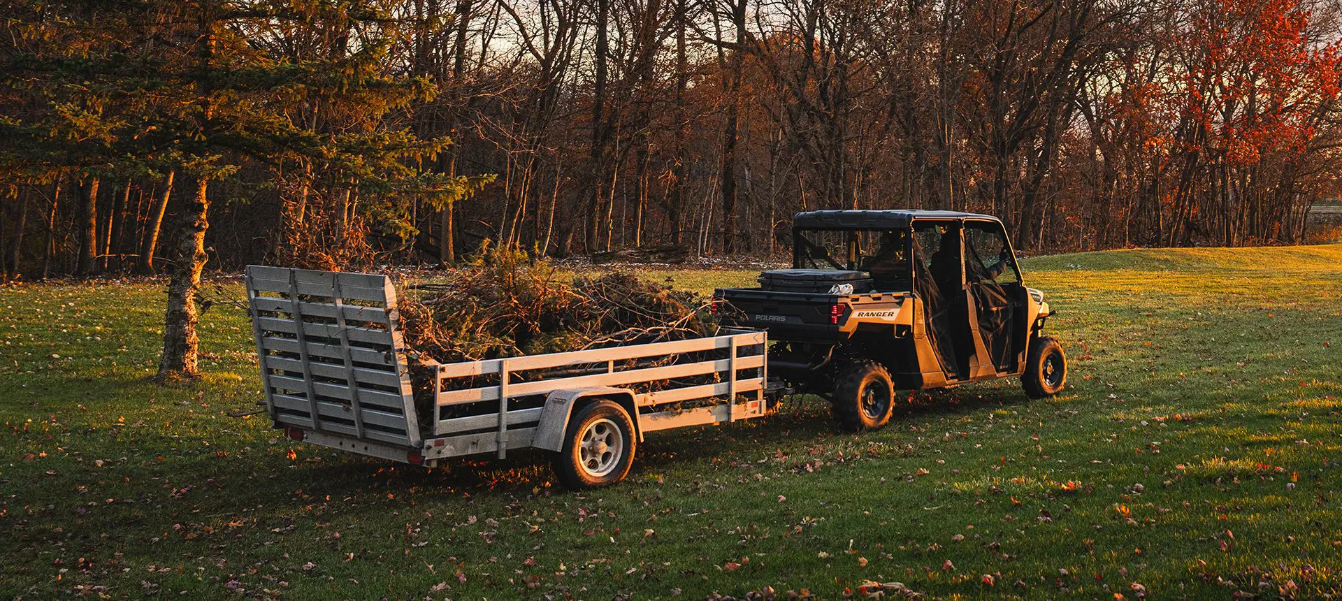 Aluminum trailer loaded with forest debris being pulled by a Polaris RANGER CREW 1000 UTV.