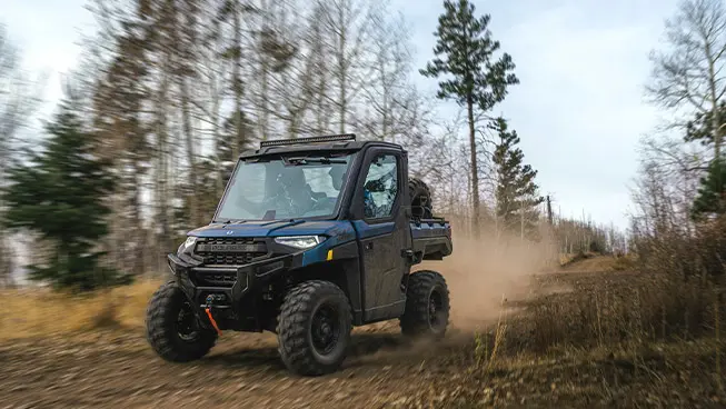 A Polaris RANGER XP 1000 NorthStar Edition UTV cruising on a dusty trail.